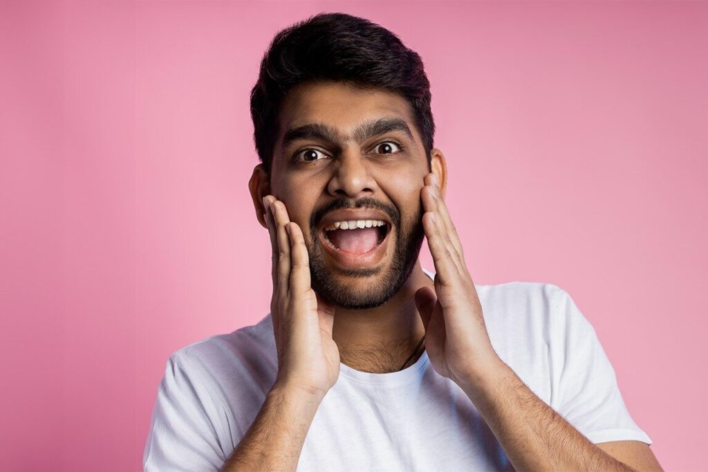 Dental Care Mistakes You Didn’t Know You Were Making 8 A cheerful person touching his cheeks showing hes happy with making the suggested changes in his dental care routine