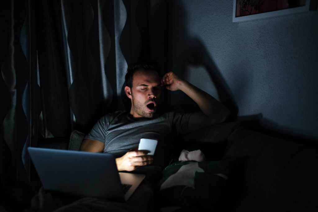 Long-Term Side Effects of High Screen Time: A Growing and Alarming Concern 2 man-sitting-sofa-with-mobile-phone-computer-yawing