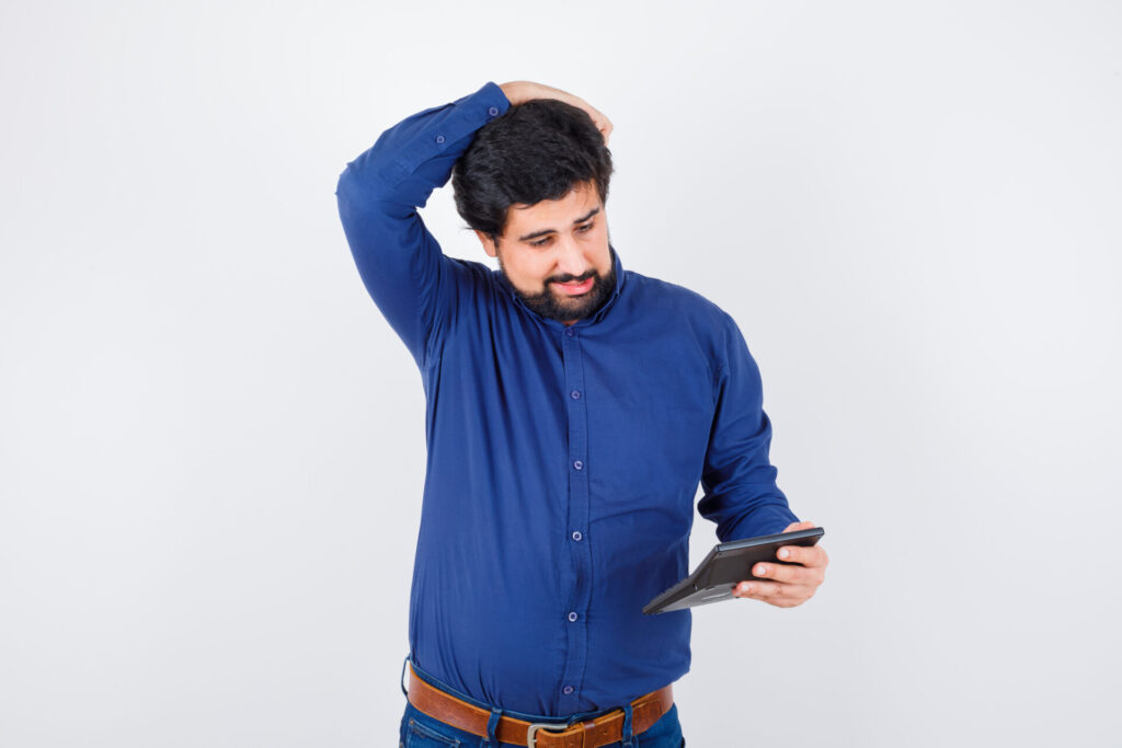 Long-Term Side Effects of High Screen Time: A Growing and Alarming Concern 3 young male looking calculator while holding hand head royal blue shirt front view