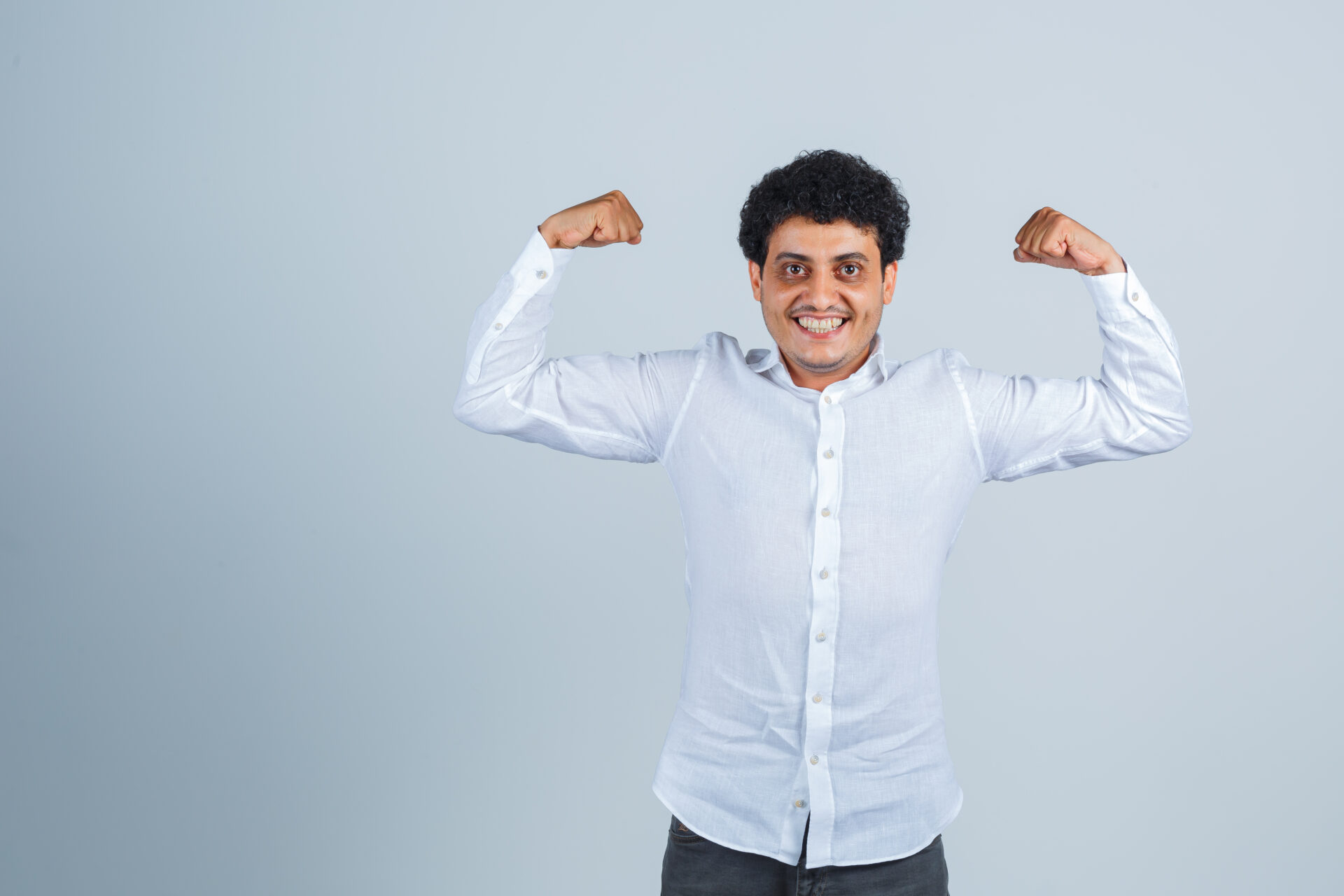 Calcium Deficiency & Calcium Rich Food to Eat: Your Guide to Strong Bones 2 young man showing muscles arms white shirt looking powerful front view