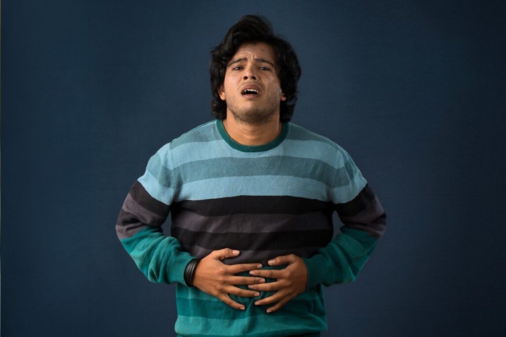 How much caffeine is too much? 2 A person holding his stomach feeling restless and uncomfortable