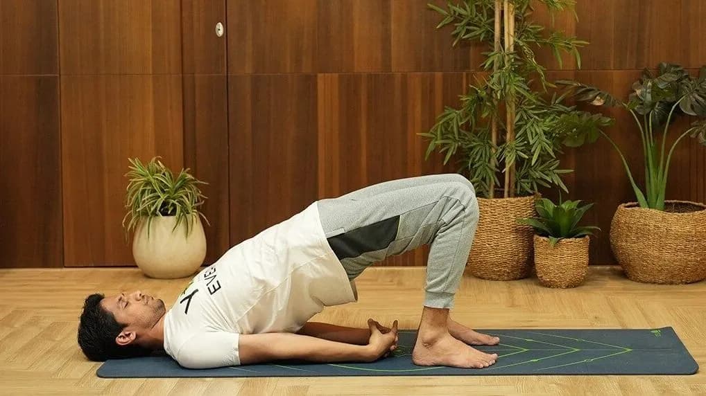 Woman performing a bridge exercise (Setu Bandhasana) for hip and glute strength