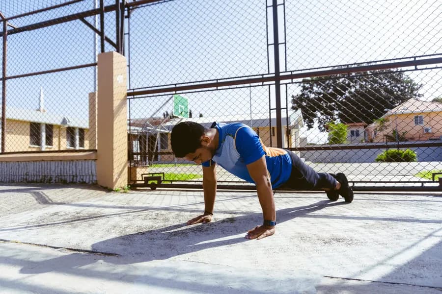 Young man doing push-ups on an outdoor court