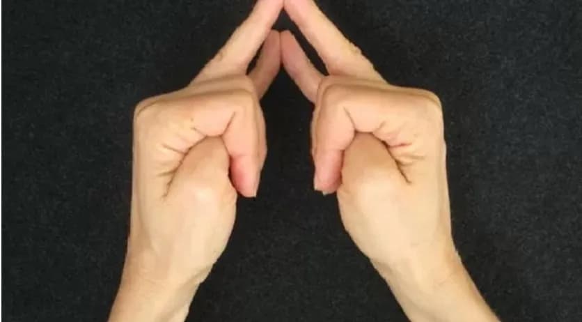 Person forming Shakti Mudra hand gesture for evening sleep practice