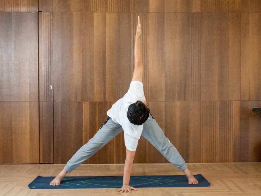 Person practicing Trikonasana triangle pose