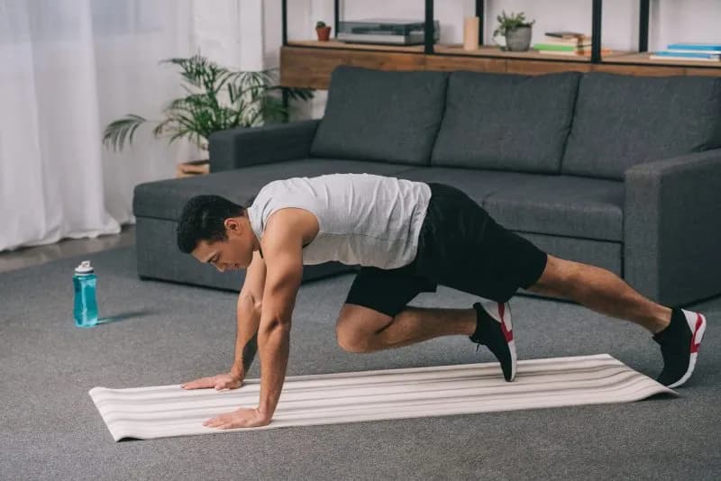 Adult man exercising on a yoga mat at home