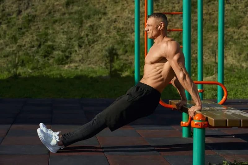 athletic-man-doing-tricep-dips-in-urban-park-2026-01-09-07-41-56-utc.jpg