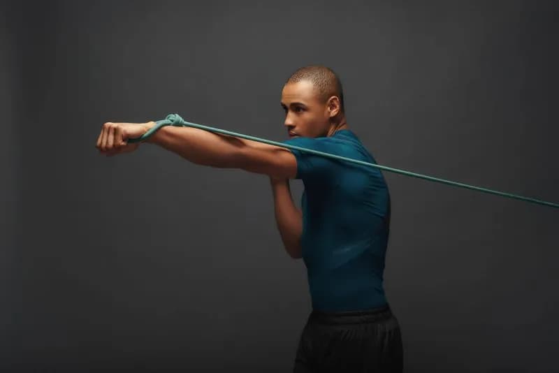 Athletic man exercising outdoors with a resistance band