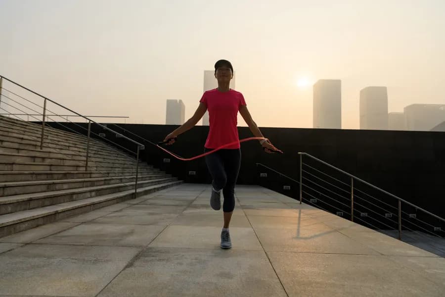 Woman skipping rope outdoors at sunrise, representing a beginner flexibility and mobility workout
