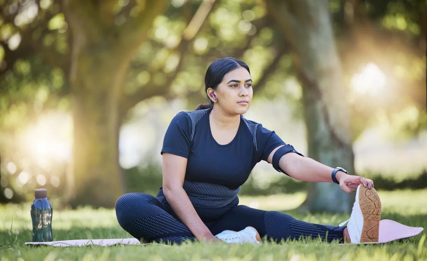Woman doing a mobility stretching exercise outdoors in a park