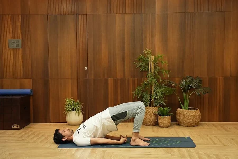 Person performing a glute bridge exercise on a yoga mat
