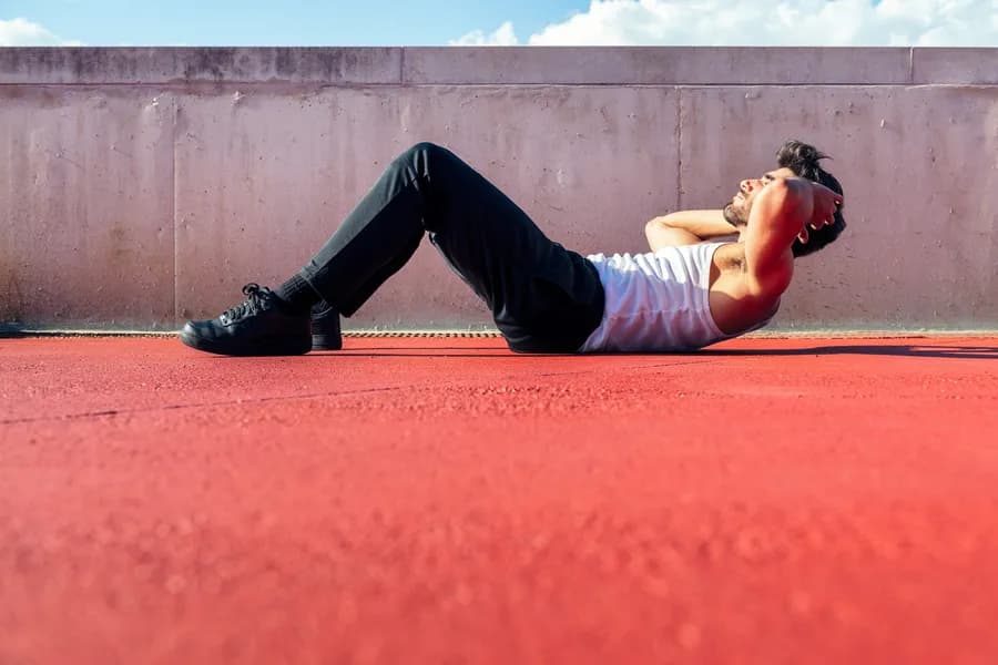 Man doing crunches outside