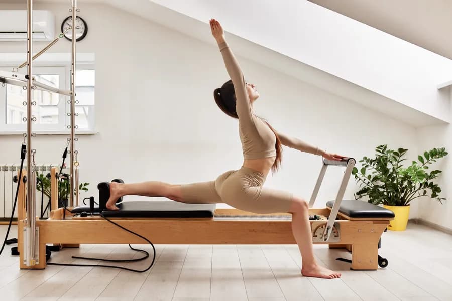 A young woman practicing pilates on a reformer bed