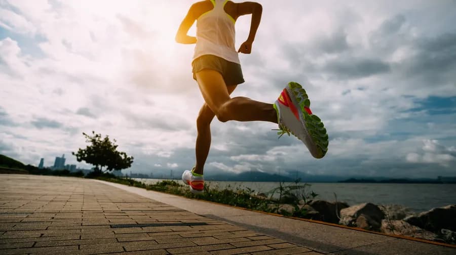 Woman running outdoors while training for a marathon, illustrating the benefits of running daily