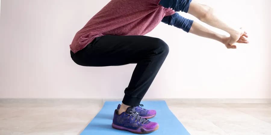 Man performing squats to build lower-body strength