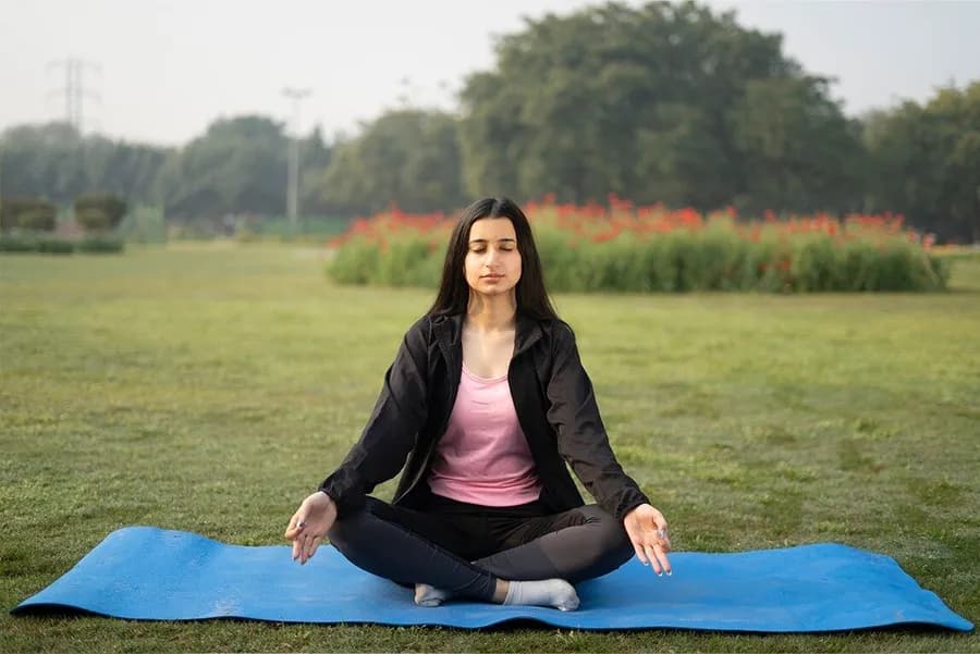 Middle-aged woman enjoying yoga as part of a body ko fit kaise rakhe fitness routine