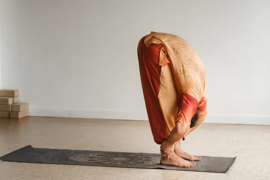Man practicing yoga in a fitness room, representing the components of physical fitness