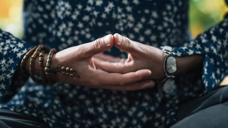 Adult meditating with hands resting in Dhyana Mudra