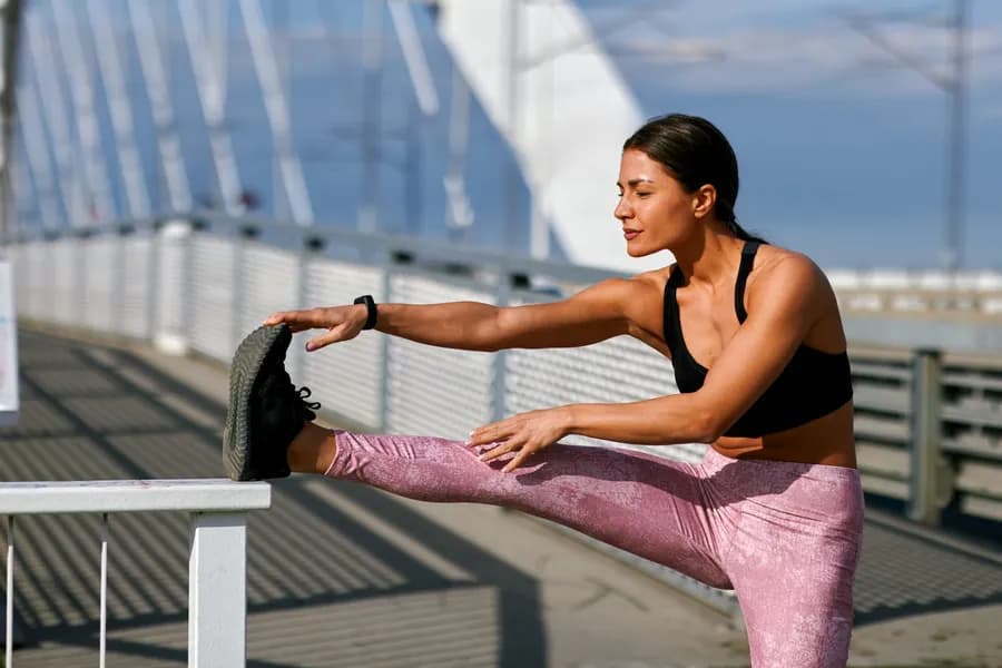 Woman doing dynamic stretching exercises outdoors