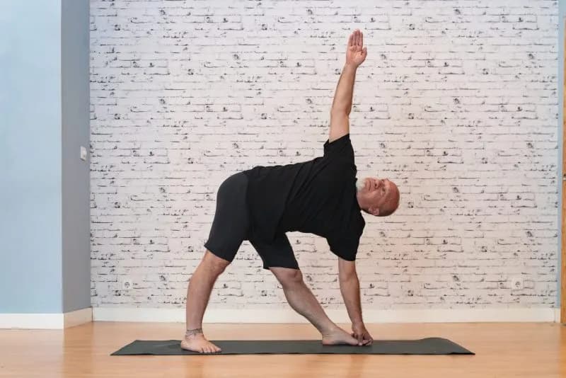 elderly man practicing yoga indoors performing a 2026 03 15 23 29 21 utc