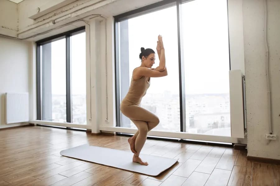 Woman in athletic wear performing an advanced balance yoga pose