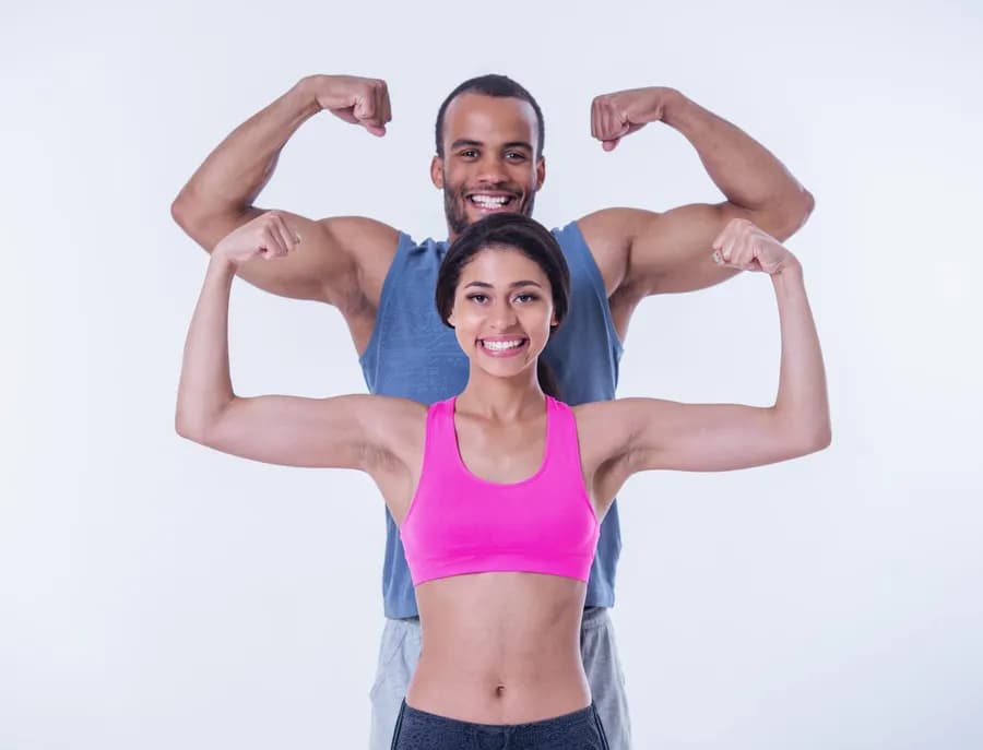 Young adults flexing muscles after a strength training session