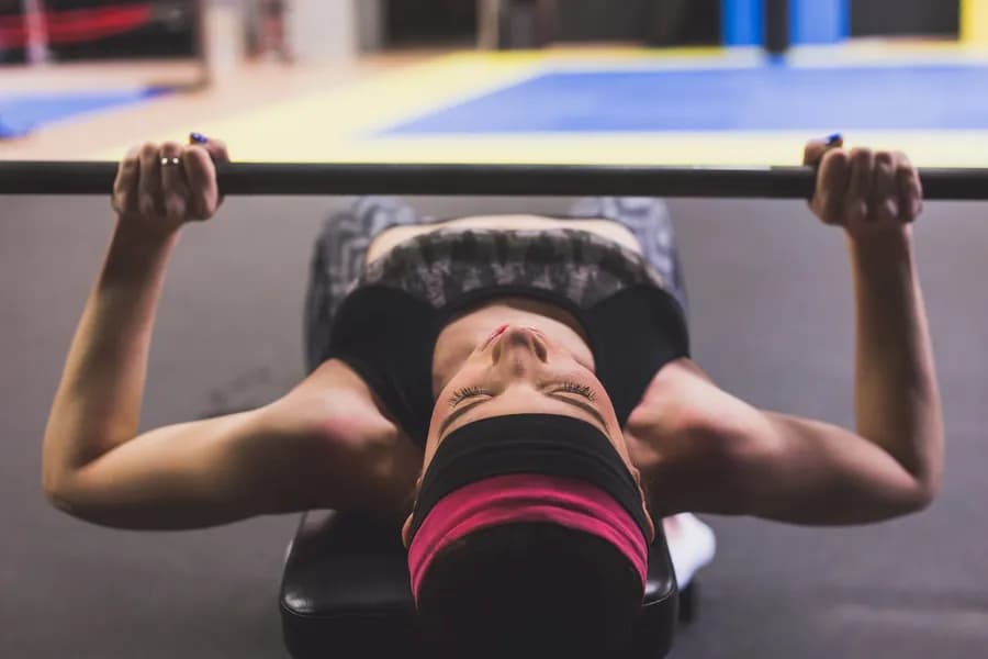 Woman lifting weights in a gym during a strength training session