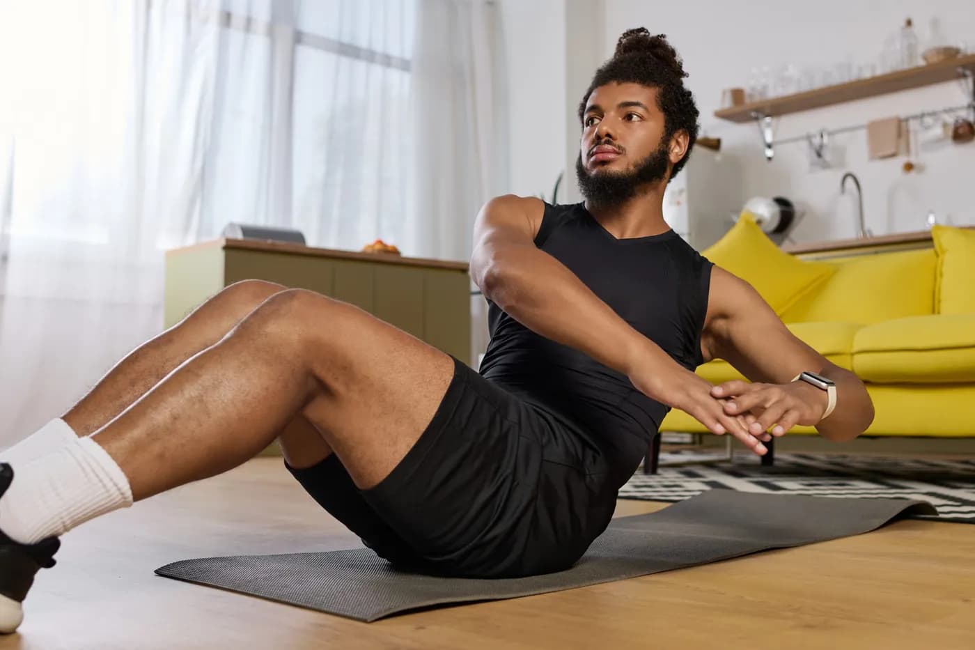 Athletic man exercising his core at home to strengthen his abdominal muscles