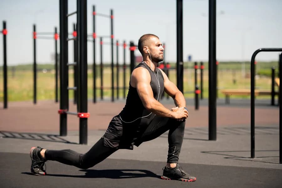 Man stretching outdoors in an urban setting during a mobility routine