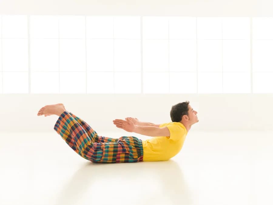 Man practicing yoga in Shalabhasana (Locust Pose)