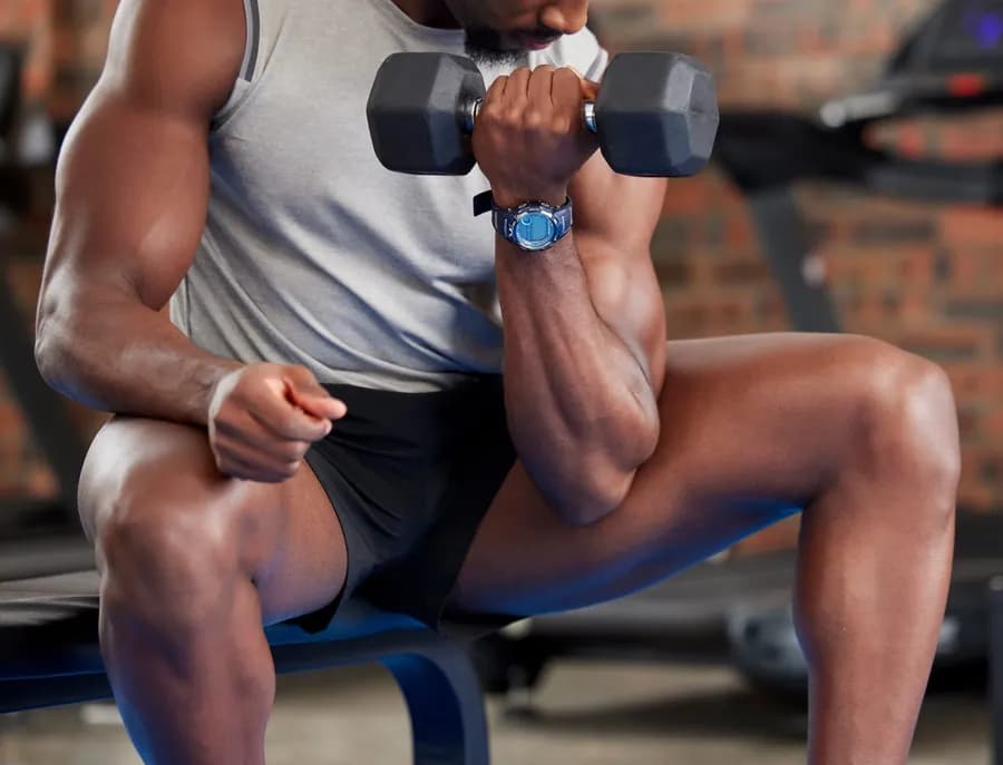 Man lifting weights in a home gym for strength training and muscle gain