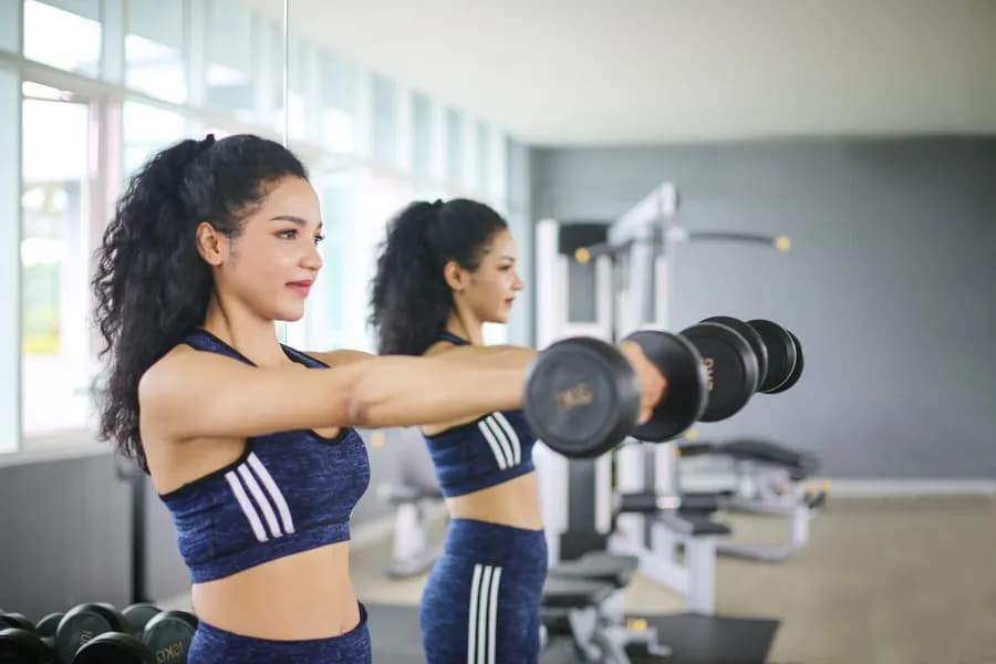 Fit woman over 40 lifting weights during a strength training workout
