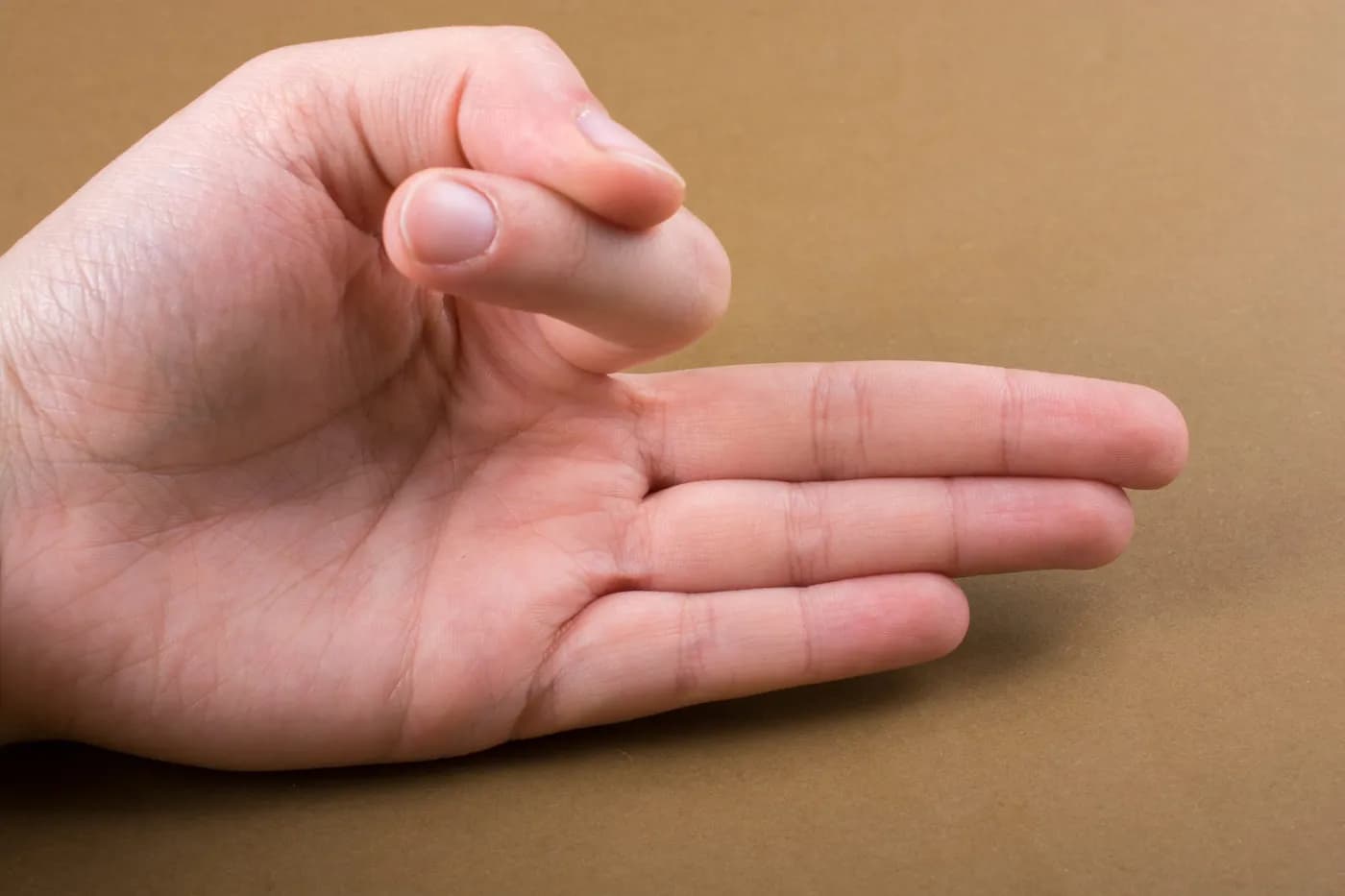 Hand making Vayu Mudra gesture on a wooden background