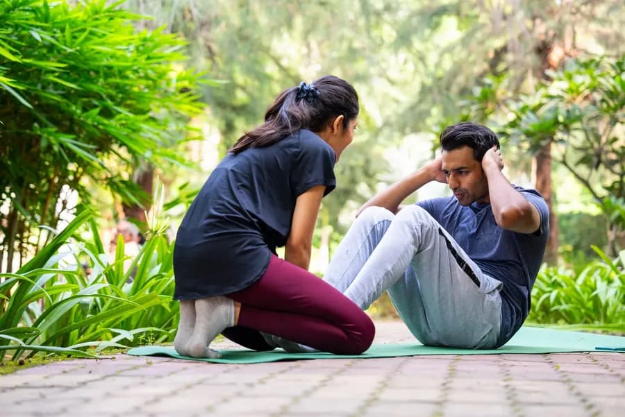 Couple doing crunches together on a mat