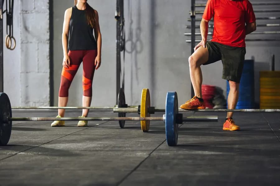Adults exercising with barbells at the gym