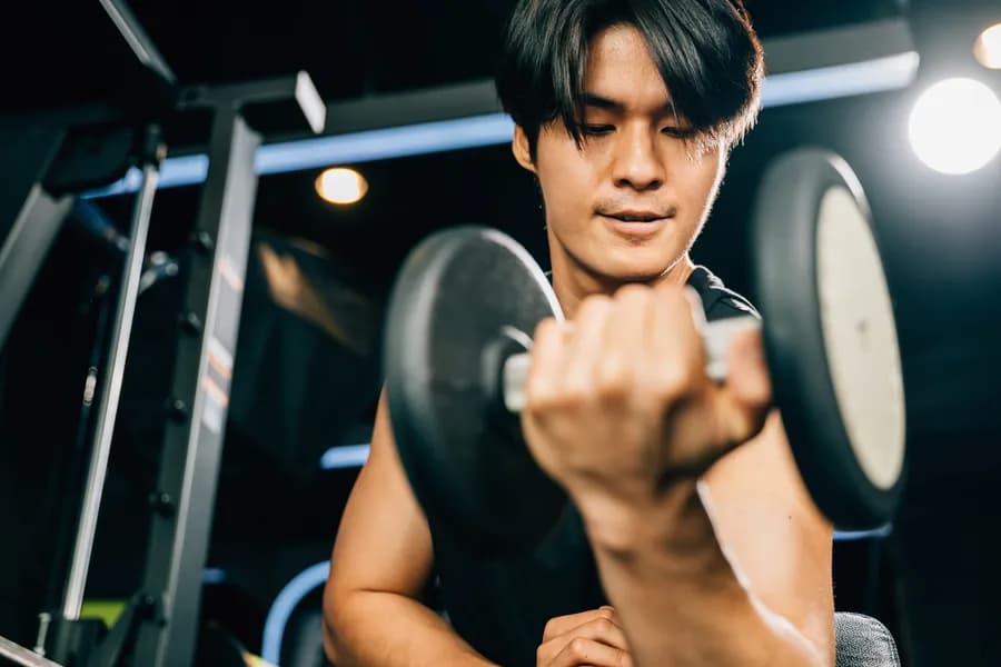 Man lifting a dumbbell during a hypertrophy strength training session