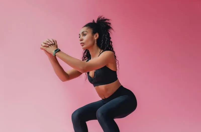 woman-doing-squats-against-pink-background-2026-03-25-10-25-14-utc.jpg