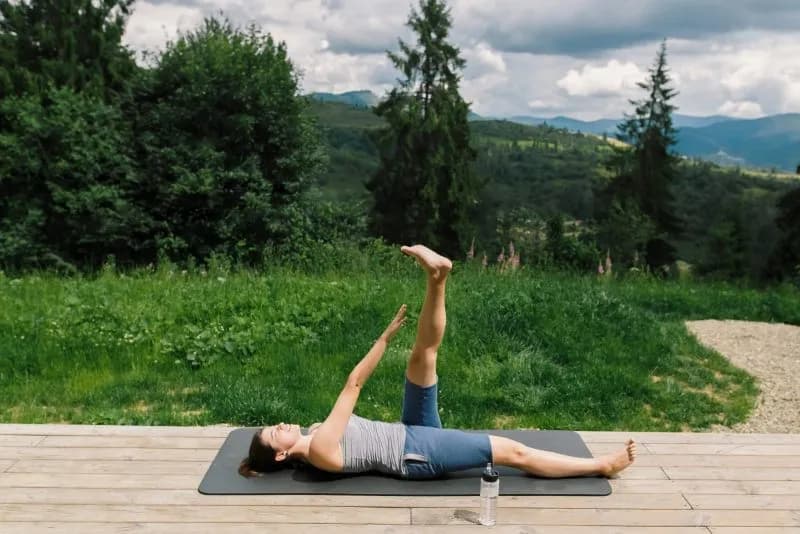 woman practicing yoga on a wooden deck outdoors 2026 01 09 00 08 07 utc