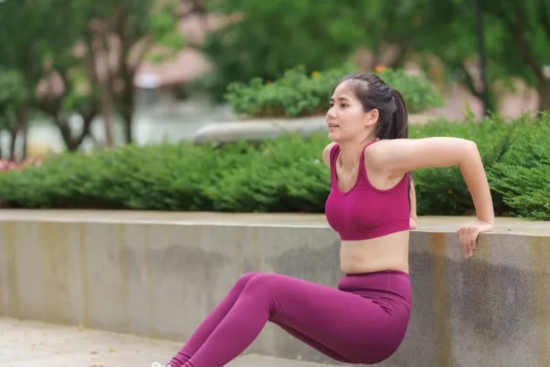 young asian woman performing triceps dips exercise 2026 01 09 11 04 06 utc