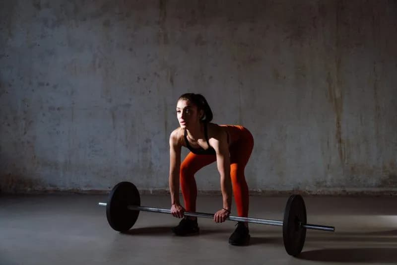 Young woman performing strength training exercises in a gym