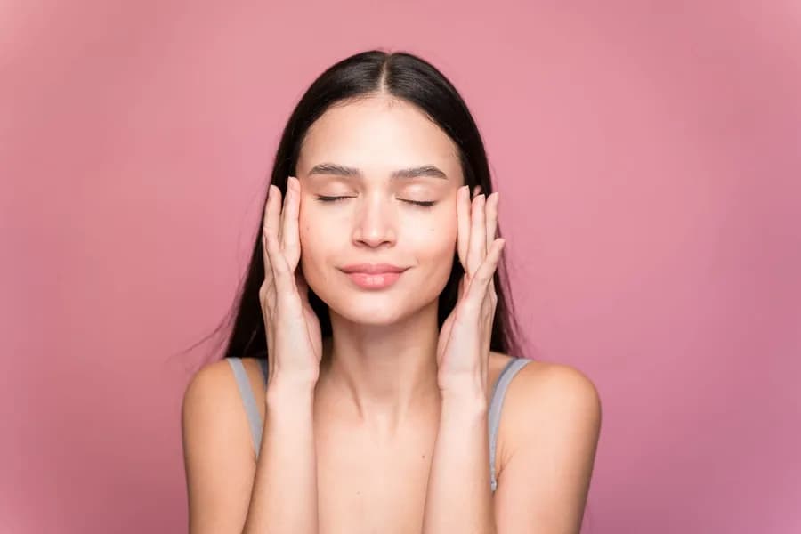Young woman massaging her face