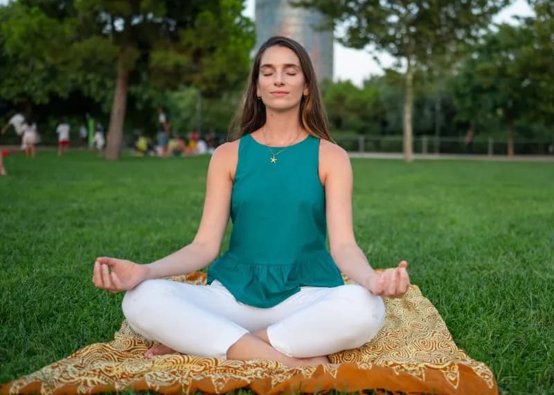 young woman meditating in lotus pose at city park 2026 01 08 08 15 10 utc